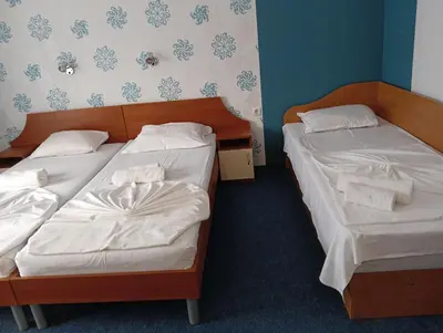 two beds in a room with white sheets at ,,Дироси'' in Sveti Vlas