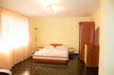 a bedroom with a bed in the corner of a room at ,,Дироси'' in Sveti Vlas