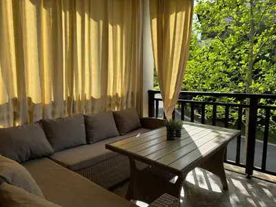 a living room with a couch and a table on a balcony at Santa Marina Apartment 513 in Sozopol