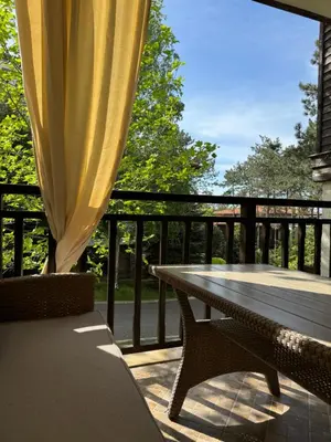 a wooden deck with a table and a curtain at Santa Marina Apartment 513 in Sozopol