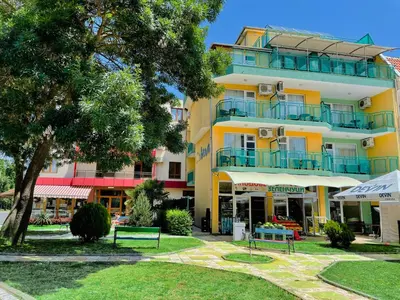 a yellow building with balconies on the side of it at Family Hotel Avenue in Kiten