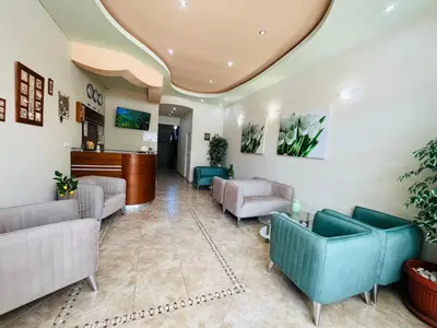 a waiting room with couches and chairs in a lobby at Family Hotel Avenue in Kiten