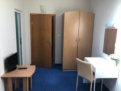 a room with a desk and a table and a cabinet at Family Hotel Avenue in Kiten