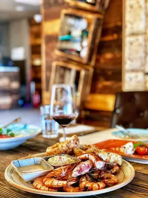 a table with a plate of food and a glass of wine at Obzor Beach Resort in Obzor