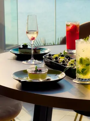 a table with plates of food and a glass of wine at Hotel Antea - By The Sea in Sozopol