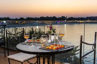 a table with wine glasses and a plate of fruit at Hotel Antea - By The Sea in Sozopol