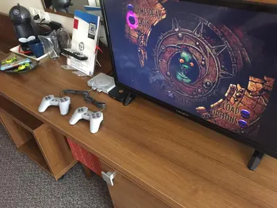a tv and two video game controllers on a desk at Hotel Burgas in Burgas City