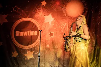 a woman playing a saxophone on a stage at MPM Hotel Kalina Garden - All Inclusive in Sunny Beach