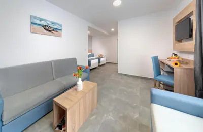 a living room with a blue couch and a table at Martinez Hotel All Inclusive in Sozopol