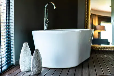 a bath tub with three vases sitting next to a mirror at mOdus Hotel in Varna City