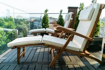 three lounge chairs sitting on a deck on a balcony at mOdus Hotel in Varna City
