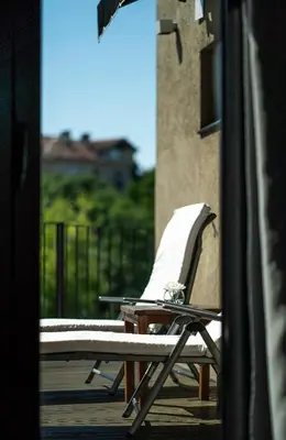 a lounge chair sitting on a deck with a building at mOdus Hotel in Varna City