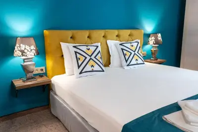 a bedroom with a large white bed with two lamps at Royal Calisto Hotel in Sozopol