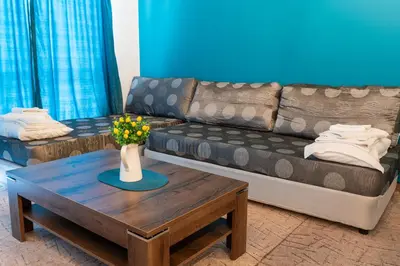 a living room with a couch and a coffee table at Royal Calisto Hotel in Sozopol