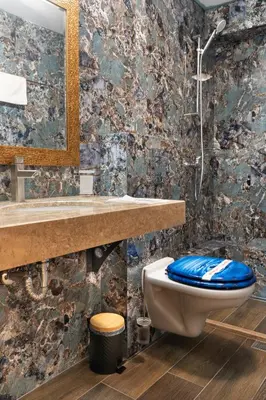 a bathroom with a blue toilet and a sink at Royal Calisto Hotel in Sozopol
