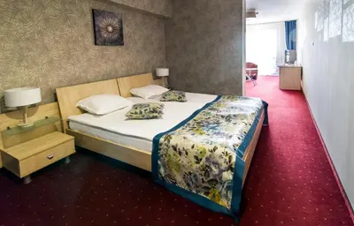 a bedroom with a bed and a red carpet at Plaza Hotel in Varna City