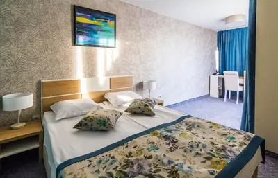 a hotel room with a bed with two pillows at Plaza Hotel in Varna City