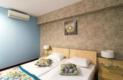 a bedroom with a bed with two pillows on it at Plaza Hotel in Varna City