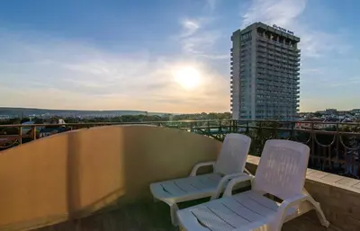 two chairs sitting on a balcony with a building at Plaza Hotel in Varna City