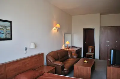 a living room with a leather couch and a television at Plaza Hotel in Varna City