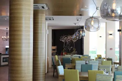 a dining room with tables and chairs and chandeliers at Aparthotel Marina Holiday Club - All Inclusive & Free Parking in Pomorie