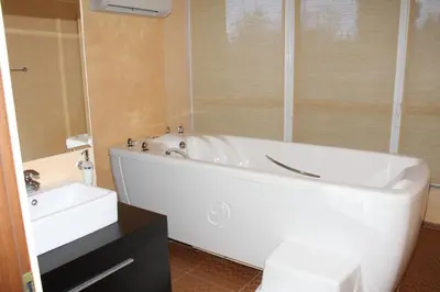a bathroom with a white tub and a sink at Aparthotel Marina Holiday Club - All Inclusive & Free Parking in Pomorie
