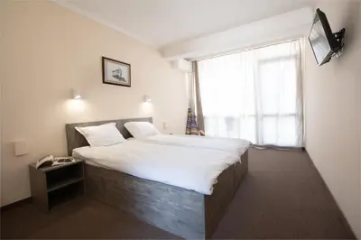 a bedroom with a large bed with a large window at Hotel Azurro - All Inclusive in Sunny Beach
