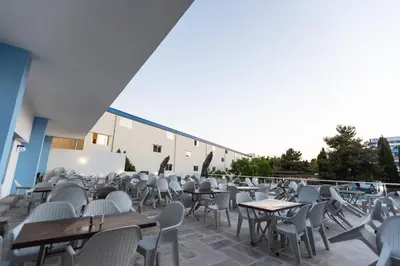 a row of tables and chairs on a patio at Hotel Azurro - All Inclusive in Sunny Beach