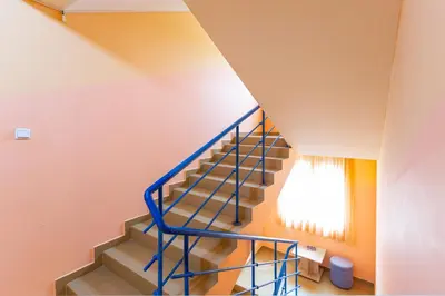 a staircase in a house with a blue railing at Family Hotel Jemelly in Obzor