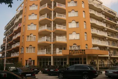 a large orange building with cars parked in front of it at Hotel Princess Residence in Kiten