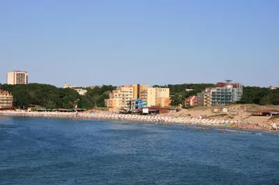 a beach with lots of white umbrellas and buildings at Hotel Princess Residence in Kiten