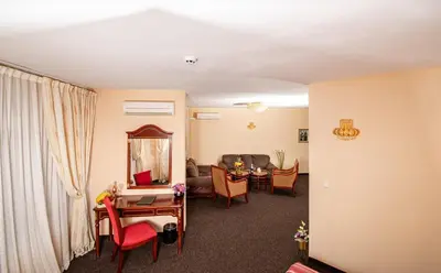 a living room with a table and a mirror at Hotel Princess Residence in Kiten