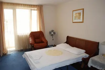 a bedroom with a bed and a chair and a window at Italia Hotel in Nesebar