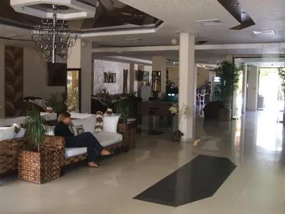 a person sitting on a couch in a lobby at Laguna Beach Resort & Spa in Sozopol