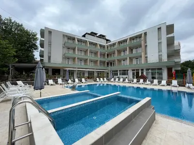 a hotel swimming pool with chairs and a hotel at Hotel Onyx in Kiten
