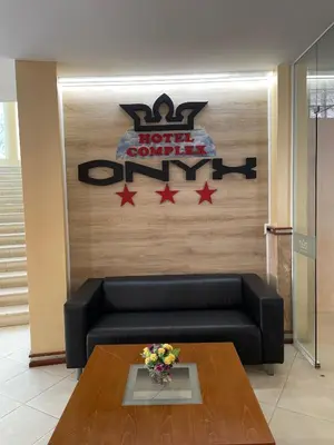 a hotel lobby with a black couch and a table at Hotel Onyx in Kiten