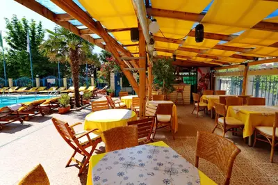 an outdoor restaurant with tables and chairs and a pool at Bora Bora Hotel in Sunny Beach