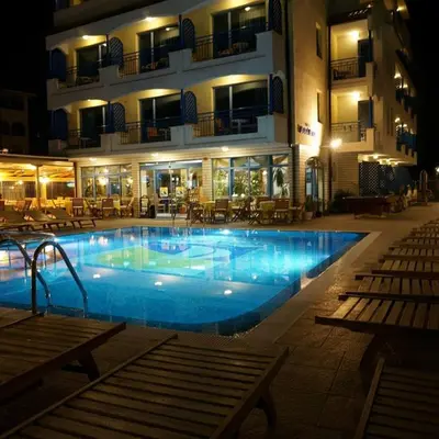 a swimming pool in front of a hotel at night at Bora Bora Hotel in Sunny Beach