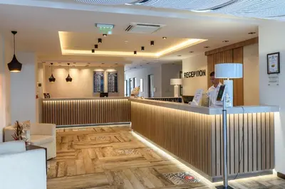 a reception area of a salon with a woman standing at a counter at Lion Sunny Beach Hotel in Sunny Beach