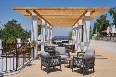 a patio with chairs and tables on a deck at Santa Marina Holiday Village in Sozopol