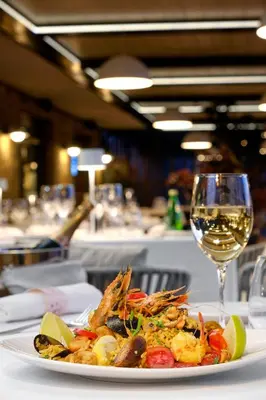 a plate of food and a glass of wine at Santa Marina Holiday Village in Sozopol