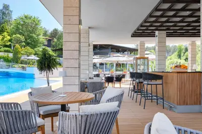 a patio with a table and chairs and a pool at Santa Marina Holiday Village in Sozopol