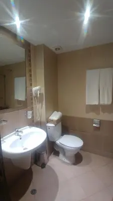 a bathroom with a sink and a toilet and a mirror at Family Hotel Muses in Sozopol