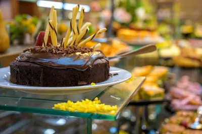 a chocolate cake sitting on a plate on a table at Effect Grand Victoria Hotel - Ultra All Inclusive in Sunny Beach