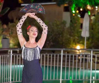 a woman holding an umbrella in front of a pool at Effect Grand Victoria Hotel - Ultra All Inclusive in Sunny Beach