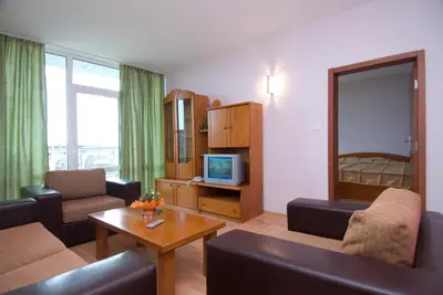 a living room with a couch and a tv and a table at Ivana Palace Hotel - Free Parking in Sunny Beach