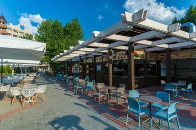 an outdoor patio with tables and chairs and umbrellas at HI Hotels Imperial Resort - Ultra All Inclusive, FREE PARKING in Sunny Beach
