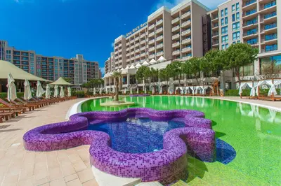 a resort pool with a purple fountain in the middle at Barcelo Royal Beach - All Inclusive in Sunny Beach