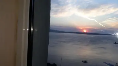 a view of the ocean from a window with the sunset at ORION Guest House in Sozopol