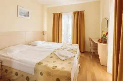 a hotel room with a bed and a desk at Serena Residence Aparthotel in Sozopol
